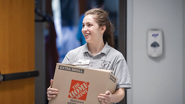 Annalise Klein stacks boxes with canned products in the Arnold Salvation Army.